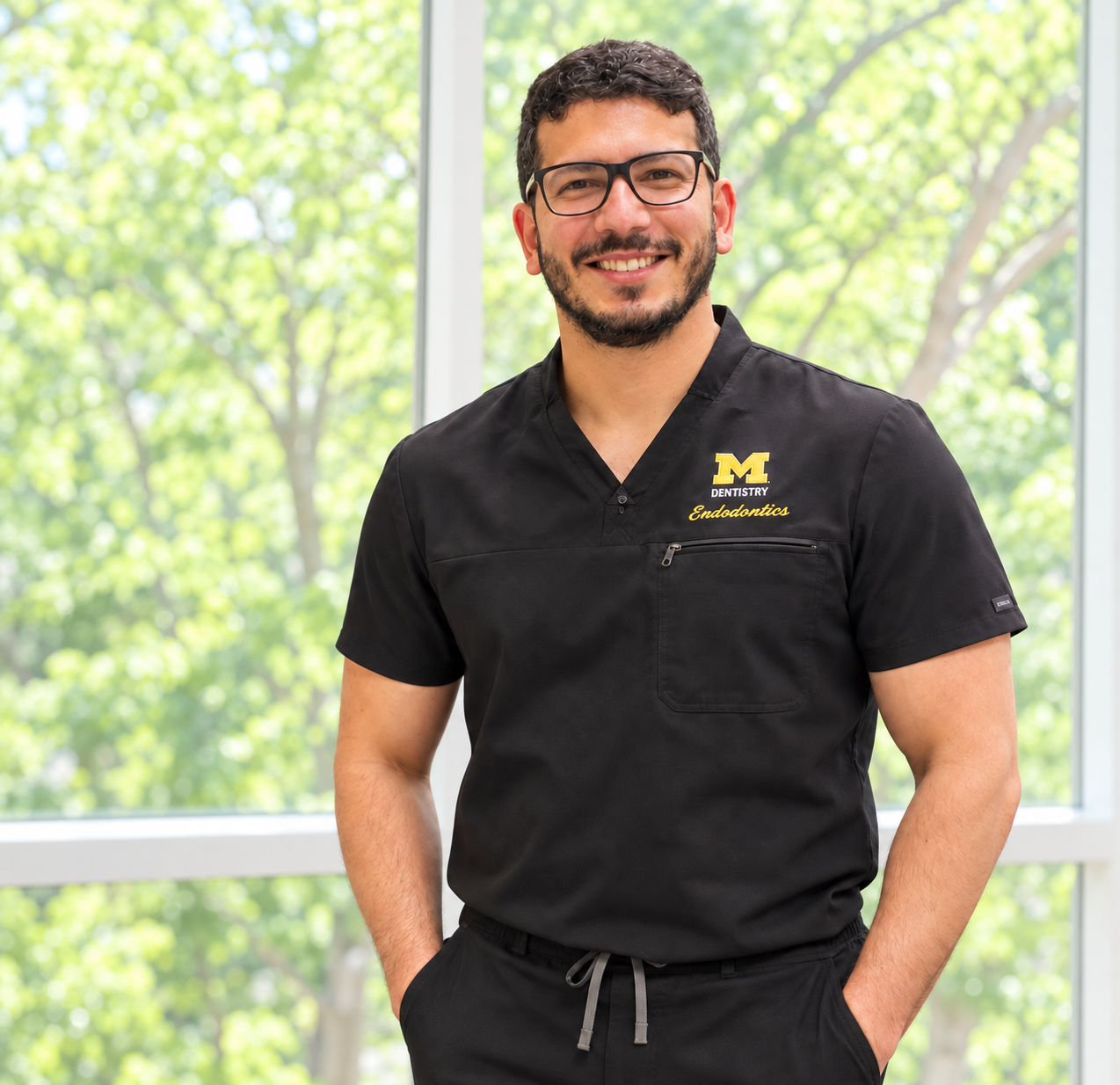 Dr. Sahil Manhas smiling in black endodontic scrubs